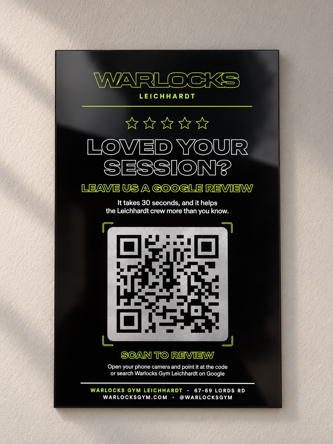 Wall-mounted black Warlocks gym Google review sign with lime lettering and QR code